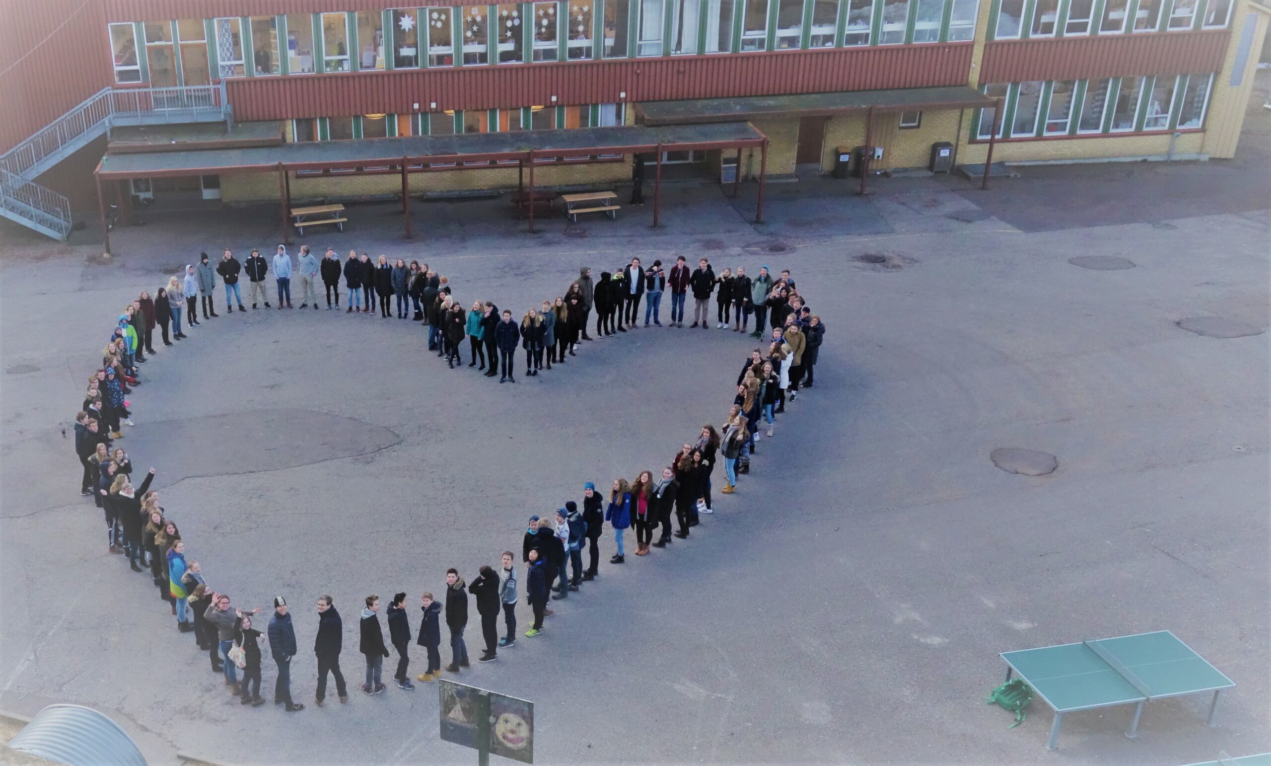Bilde av mange mennesker i hjerteformasjon foran Granly skole