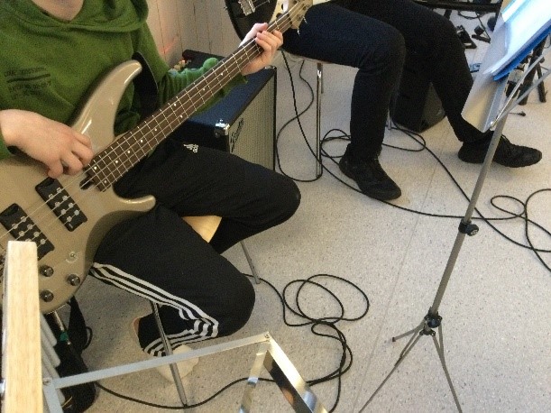 Bilde av elev som øver på el-gitar.