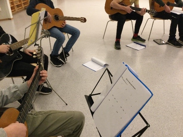 Bilde av elever som øver på instrumenter.
