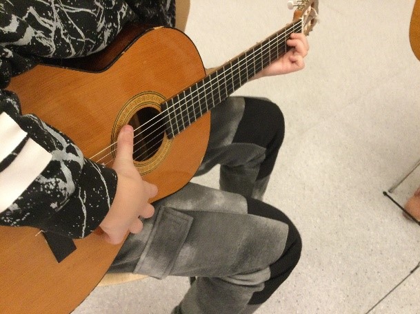 Bilde av elev som spiller gitar.