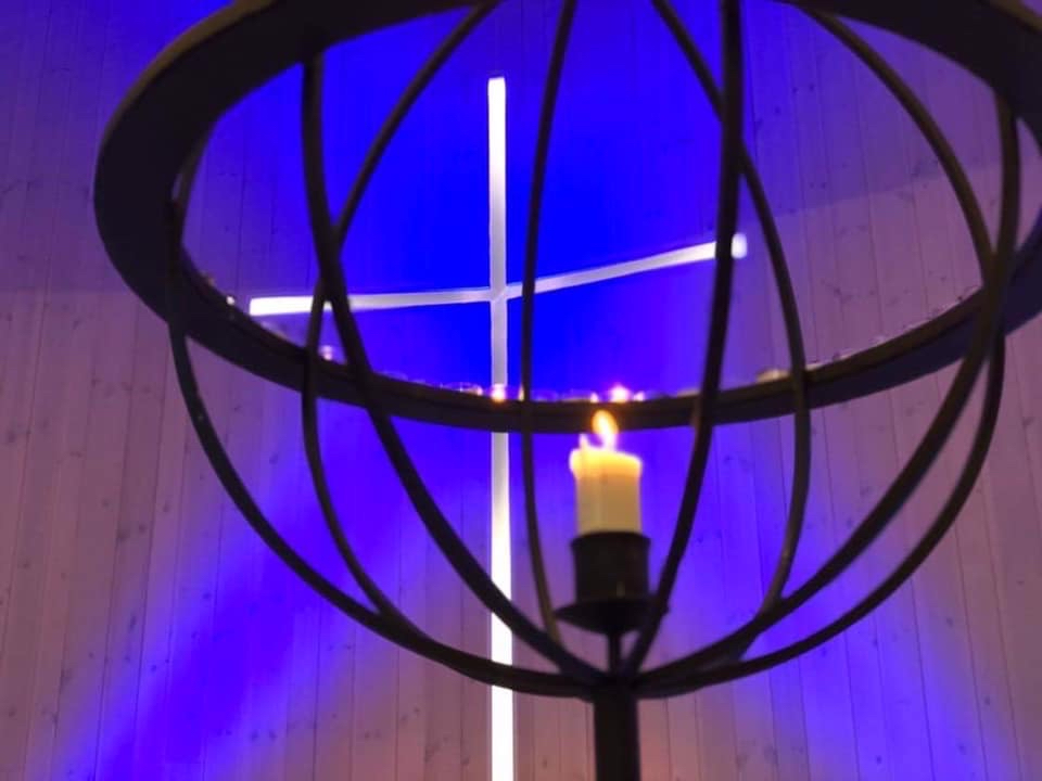 Bilde av lysglobe med alterkors i bakgrunnen.