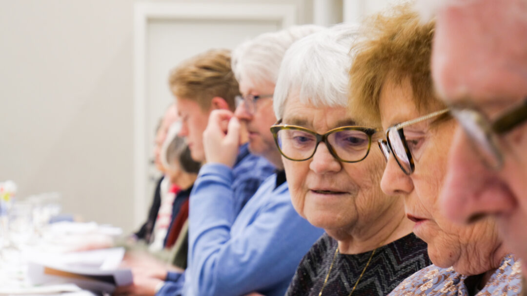 Eldre damer sitter ved festpyntet bord i Moe kirke