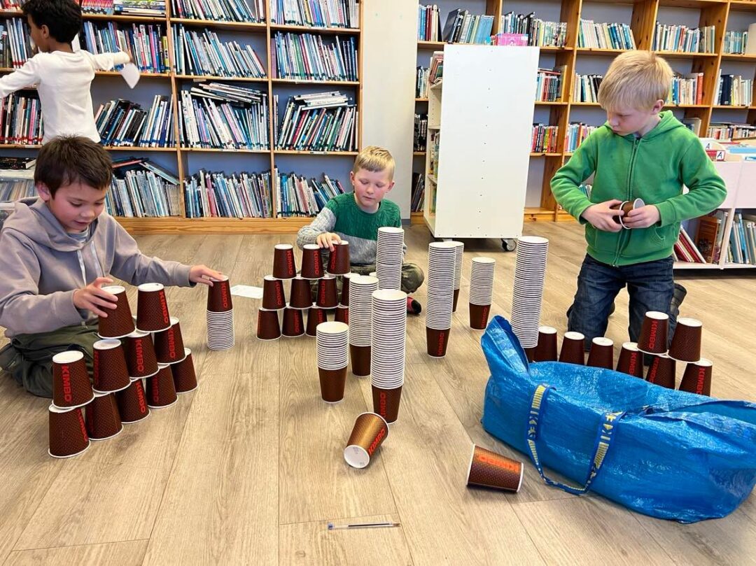 Bilde av elever som bygger tårn av kopper, på misjonskvelden.