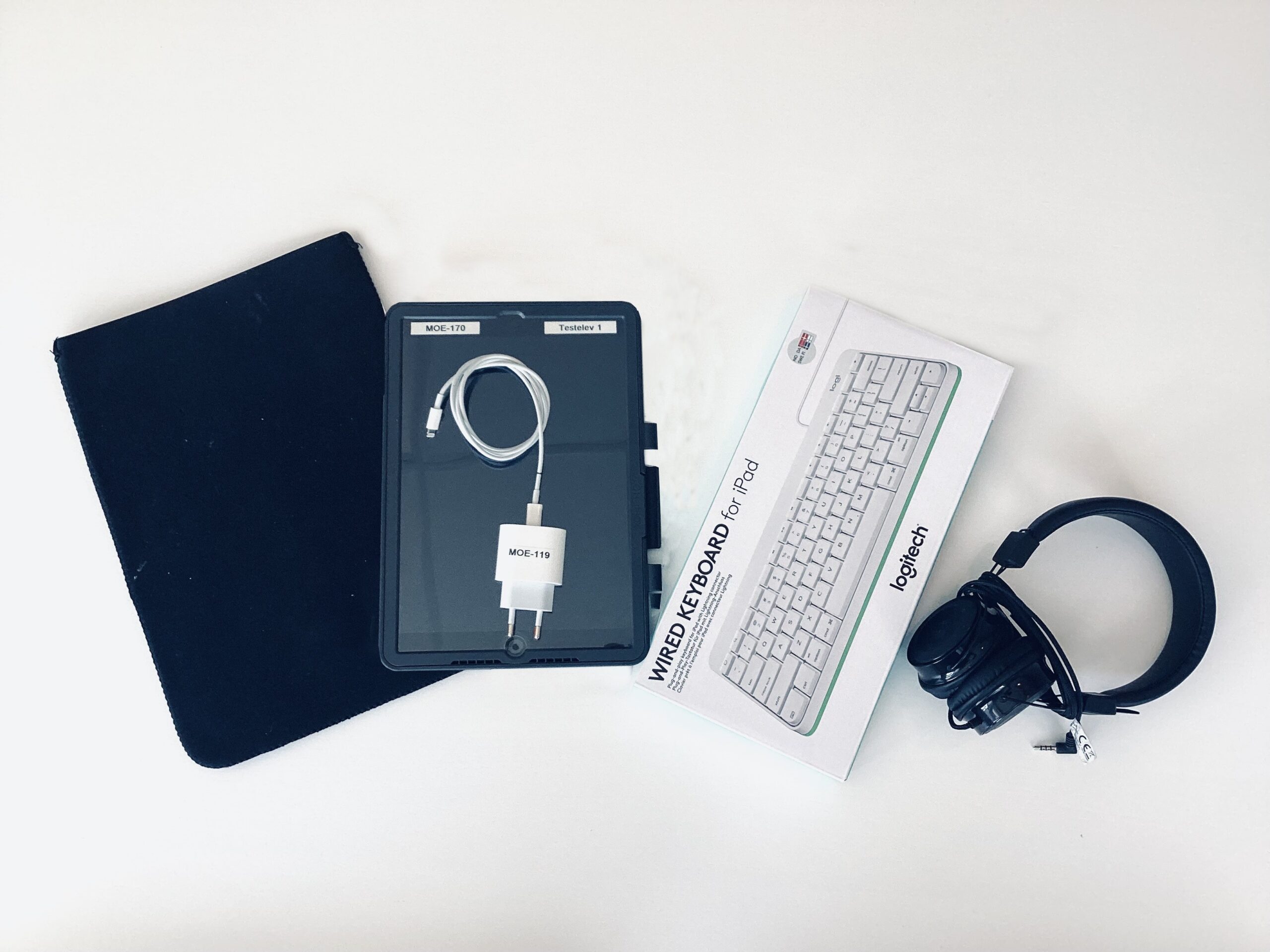 Bilde av iPad, lader, beskyttelsespose, tastatur og hodetelefoner.