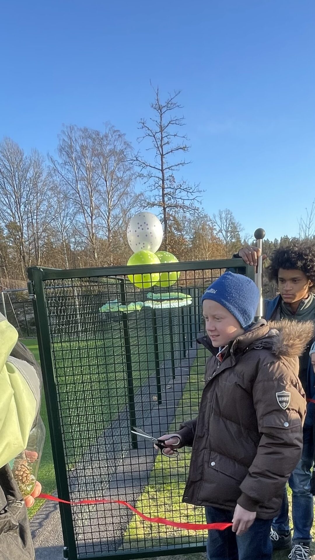 Bilde av elevrådsleder Terje som klipper snora på kunstgressbanen.