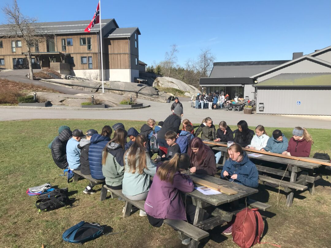Bilde 4 fra leirskolen, elever sitter konsentrert med makrame-aktivitet.