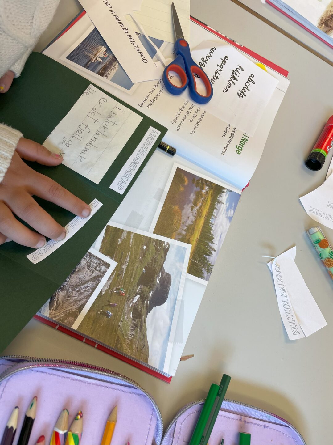 Bilde av skolepult med tegne- og skrivesaker.