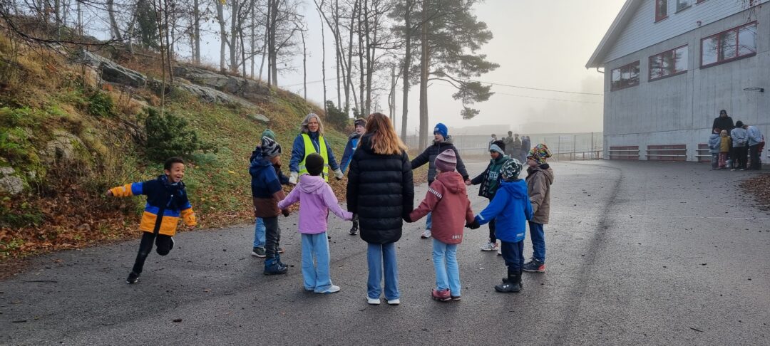 Bilde 2 av 6.-7. klasse som leker med fadderbarna i 1.-2. klasse.