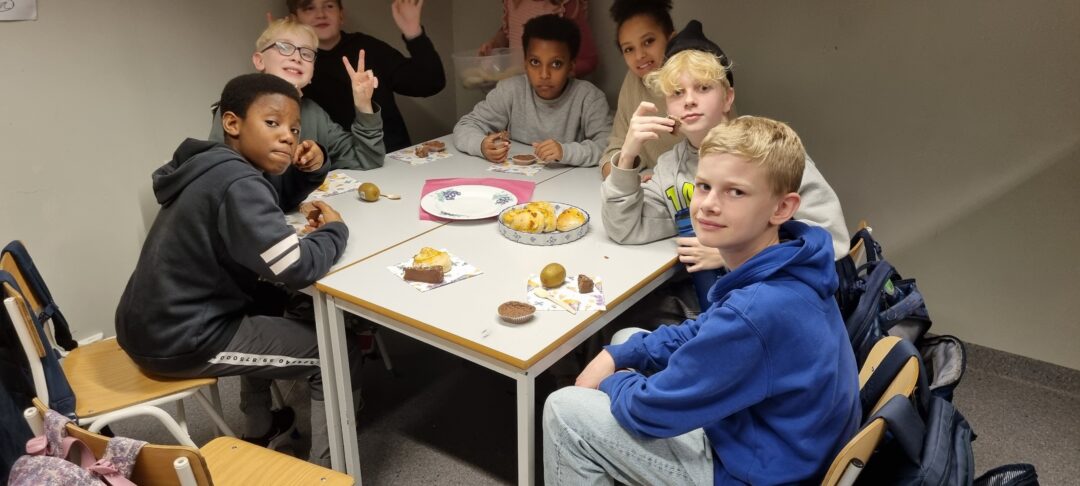 Bilde av elever med pizzasnurrer og muffins.