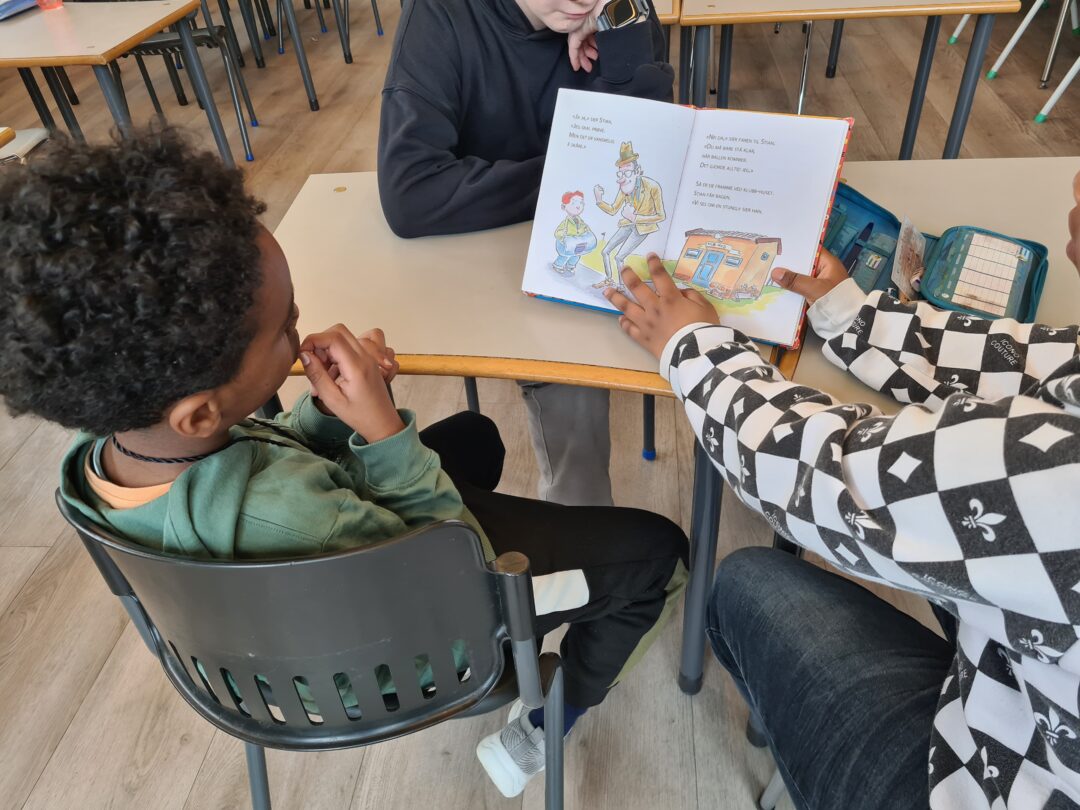 Bide av fadder som leser for fadderbarn (gutt).