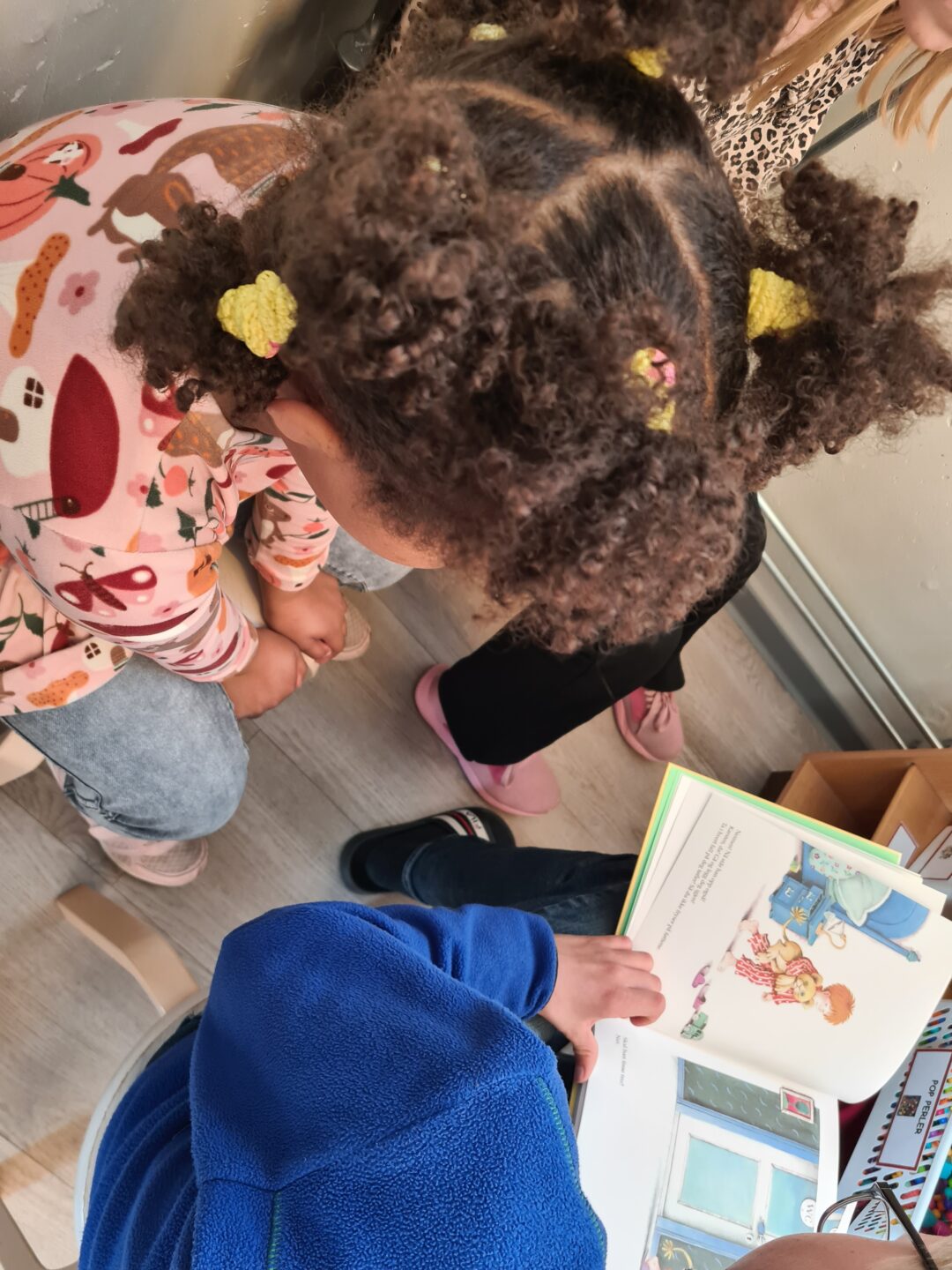 Bilde ovenfra av to elever som leser bok.