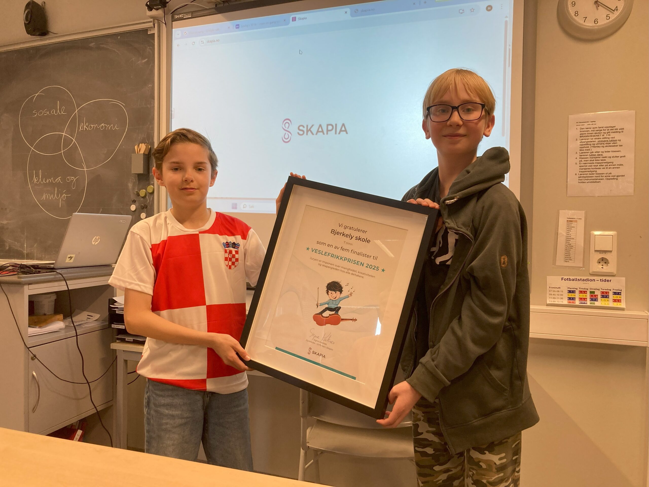 Bilde av to gutter i 7. klasse med finalist-diplom for Veslefrikkprisen 2025.
