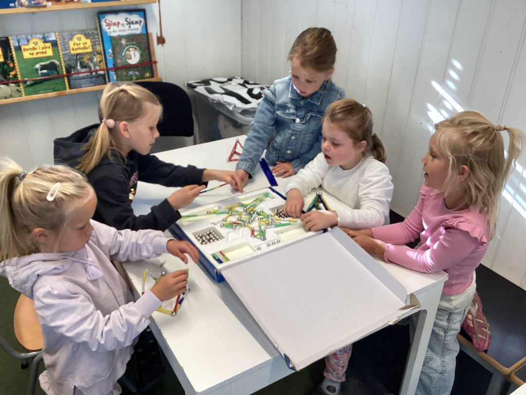 Bilde av fem jenter i 1. klasse som leker med magneter.