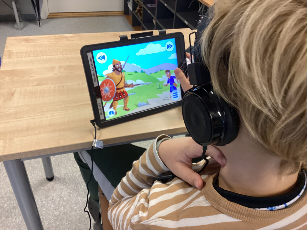Bilde av elev som ser på iPad-bilde av David og Goliat.