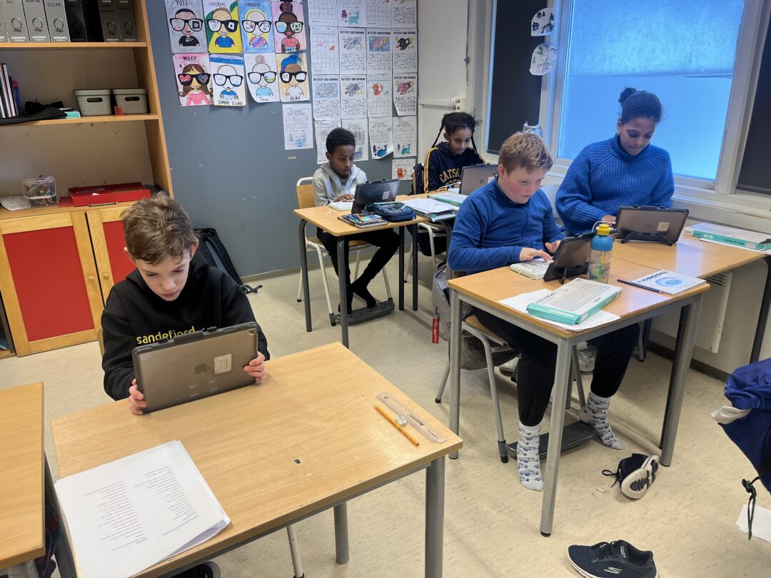 Bilde av fem elever som skriver på iPad.