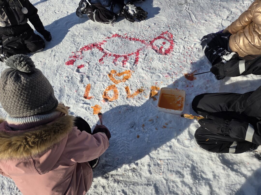 Bilde av elever som maler på snø.