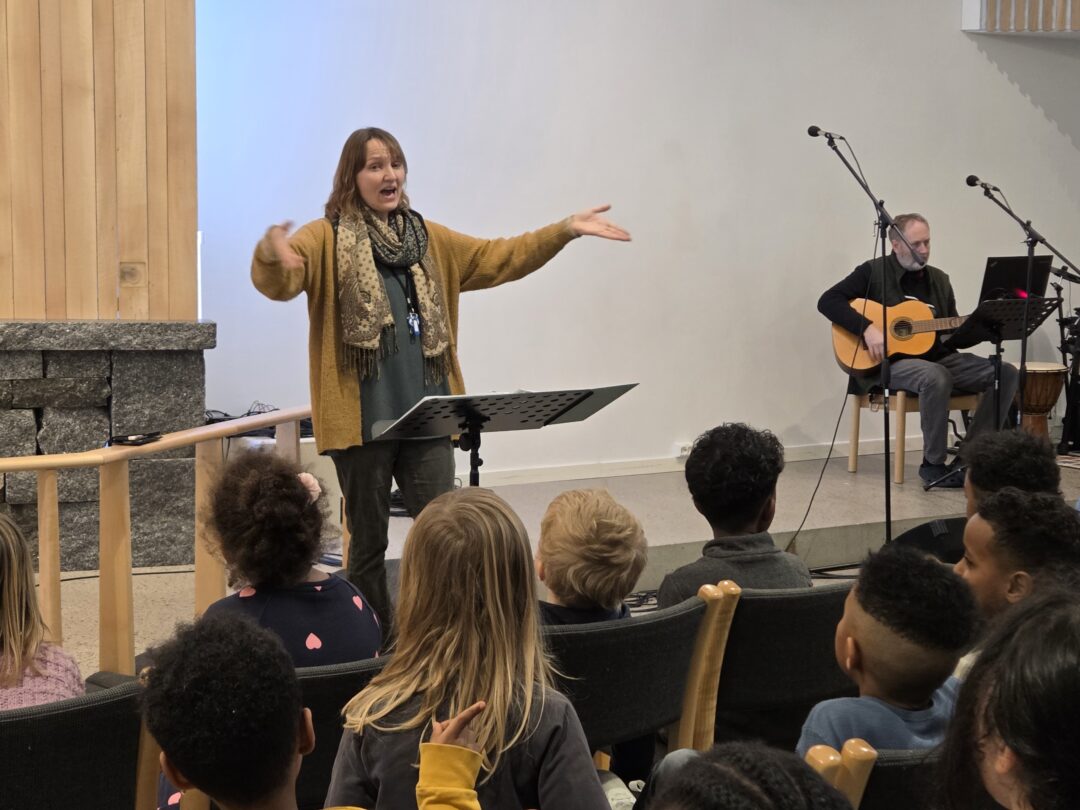 Bilde av Hege Bålsrød som dirigerer i sangøvelse i kirken.