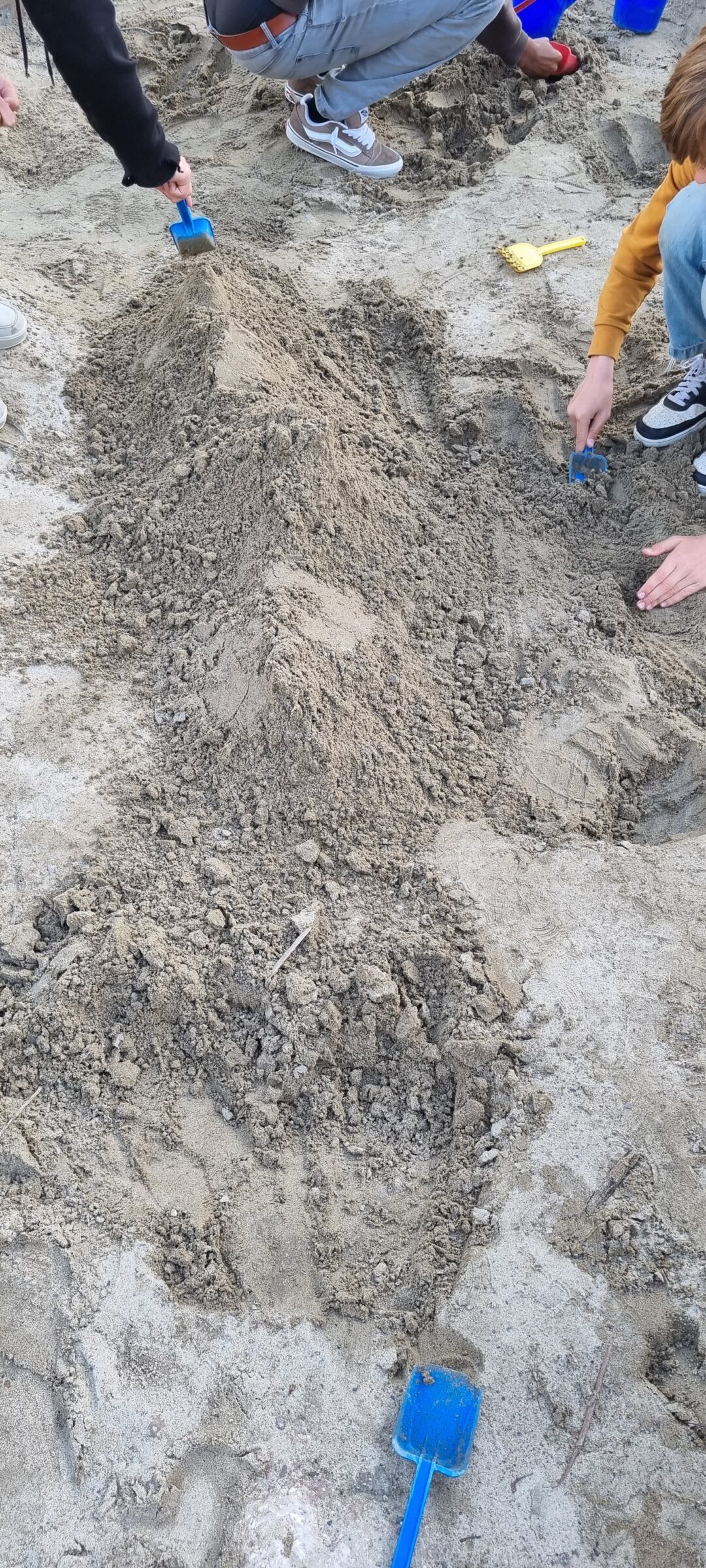 Bilde av elever som lager "fjellformasjoner" i sandkassa.