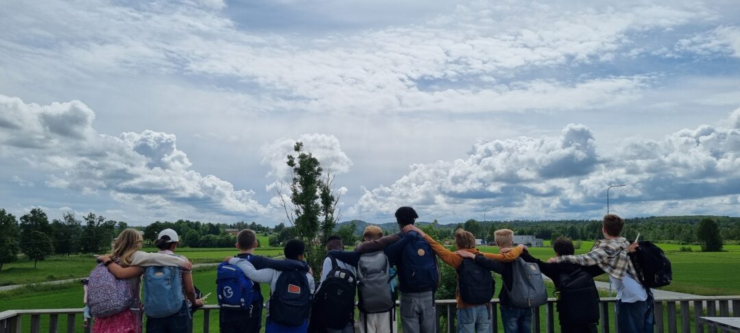 Bilde av 7. klasse, bakfra, som ser "mot Granly skole", med himmel over.