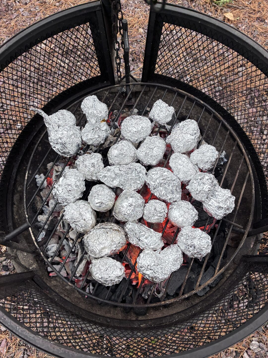 Bilde av poteter i folie som bakes på bålpanne.