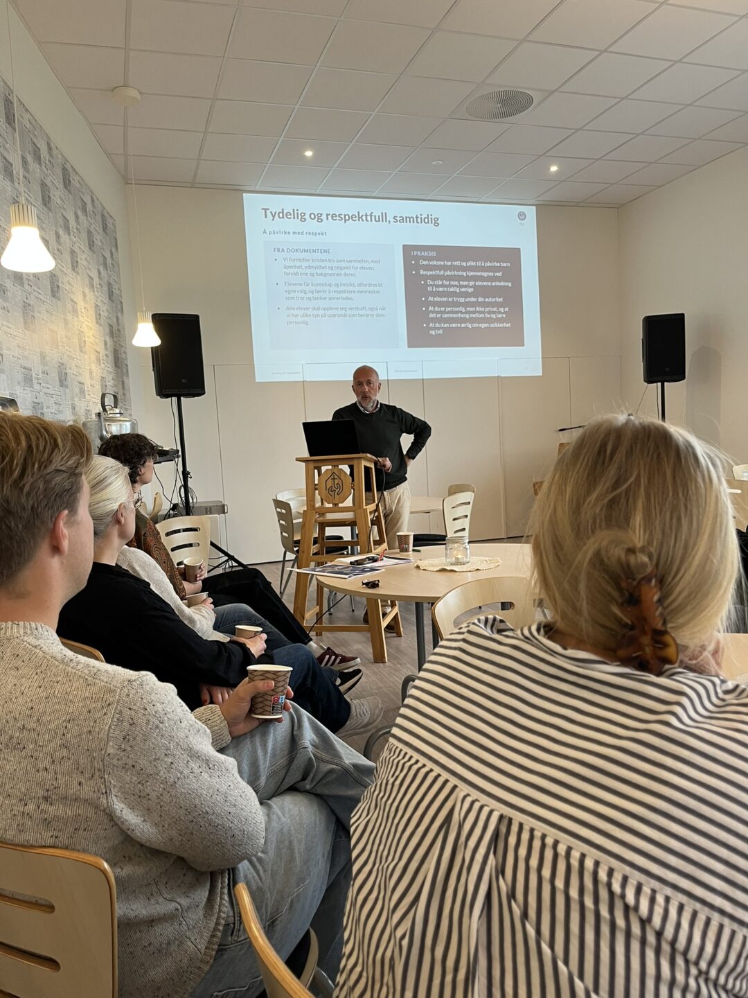 Bilde av Egil Husby på talerstolen i foajeen i Bjerkely menighetssenter.