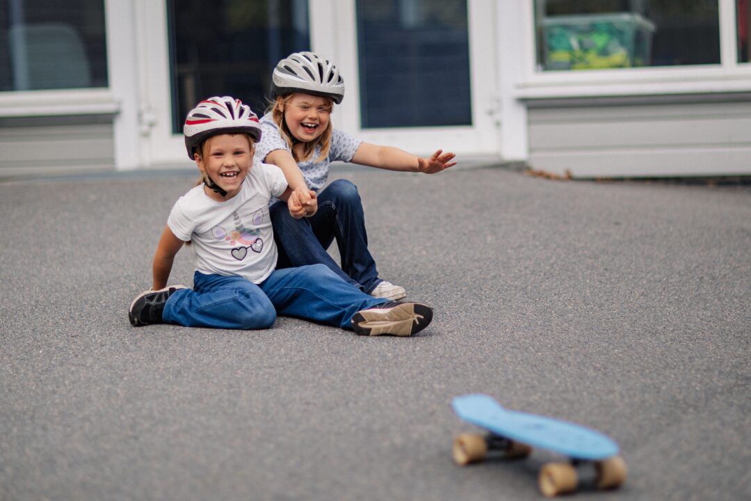 To glade jenter leker med skateboard.